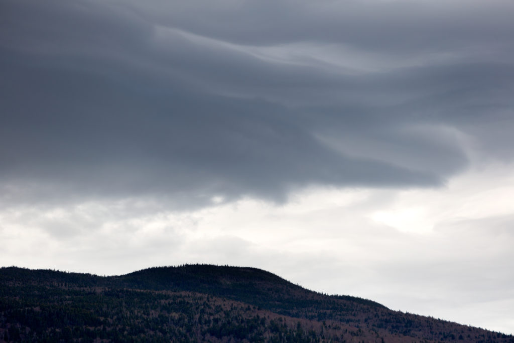 Low Hill Silhouette Under Cloudy Sky