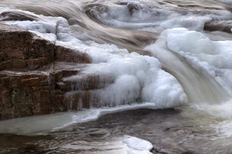 Water Flowing Through Frozen River