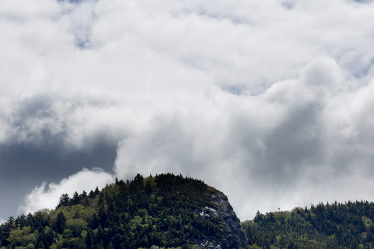 Thick Clouds Rising Behind Small Mountain