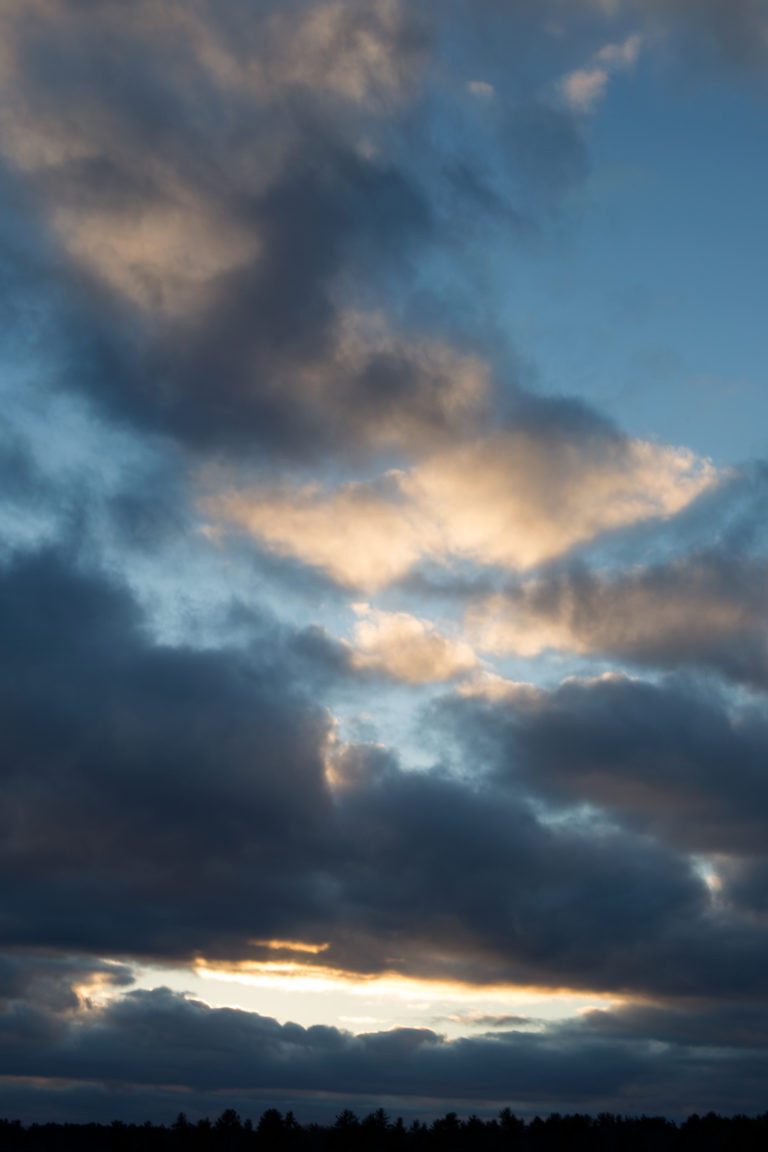 Wispy Dark Clouds Against Blue Sky