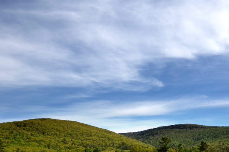 Rolling Green Hills Under Cloudy Sky